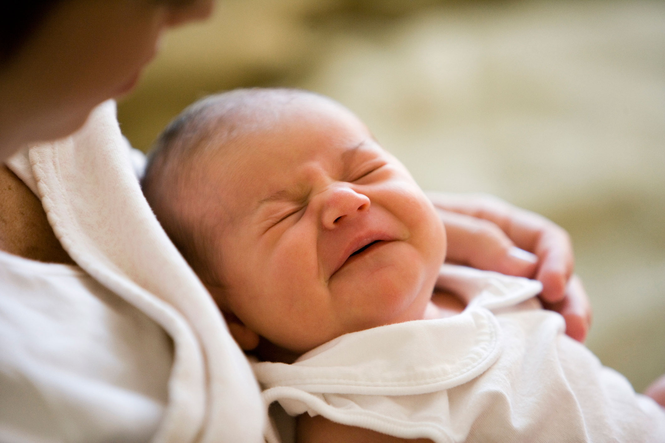 A mother holding her sleeping baby.