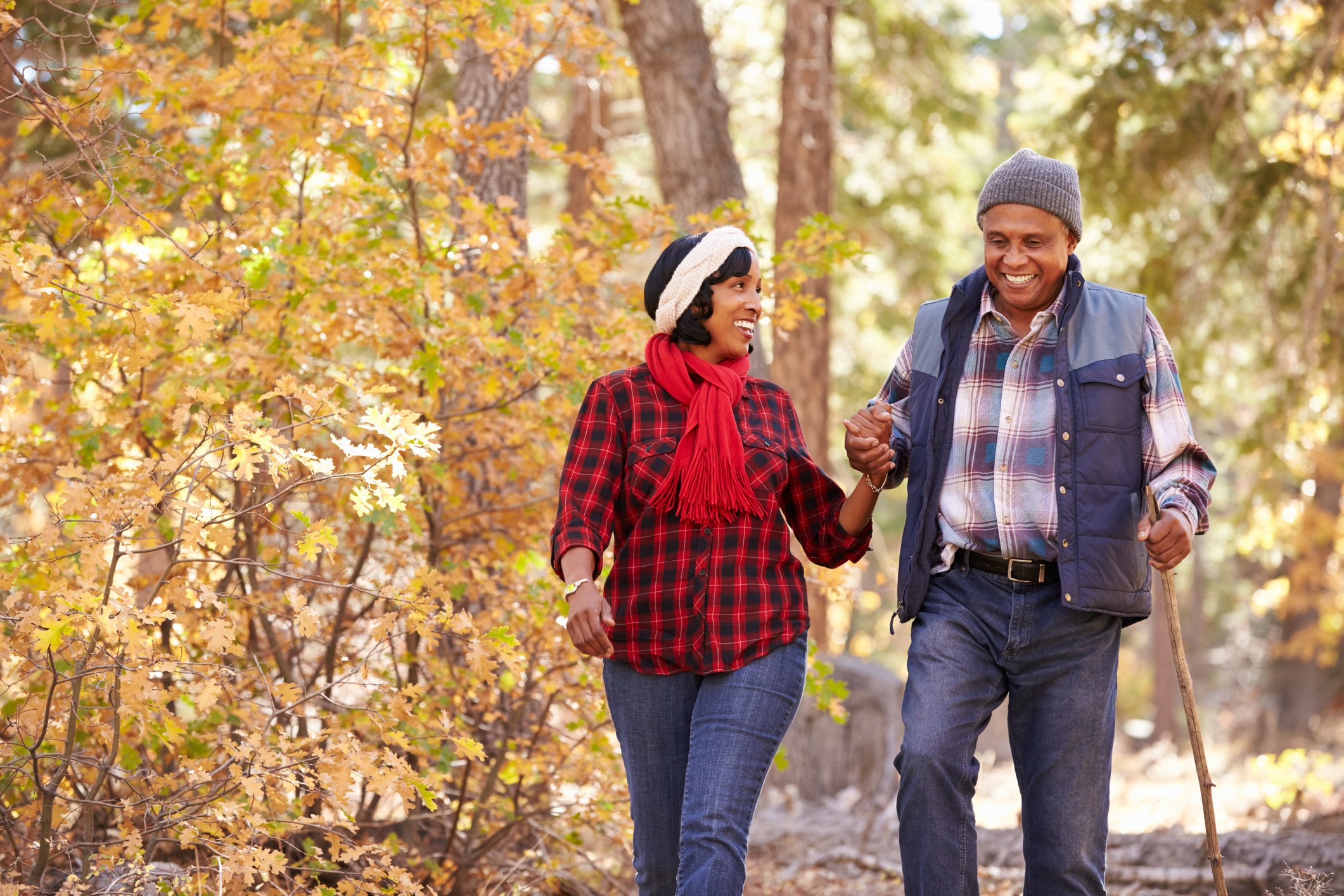 Senior African American couple walking through the woods Senior African American couple walking through the woods