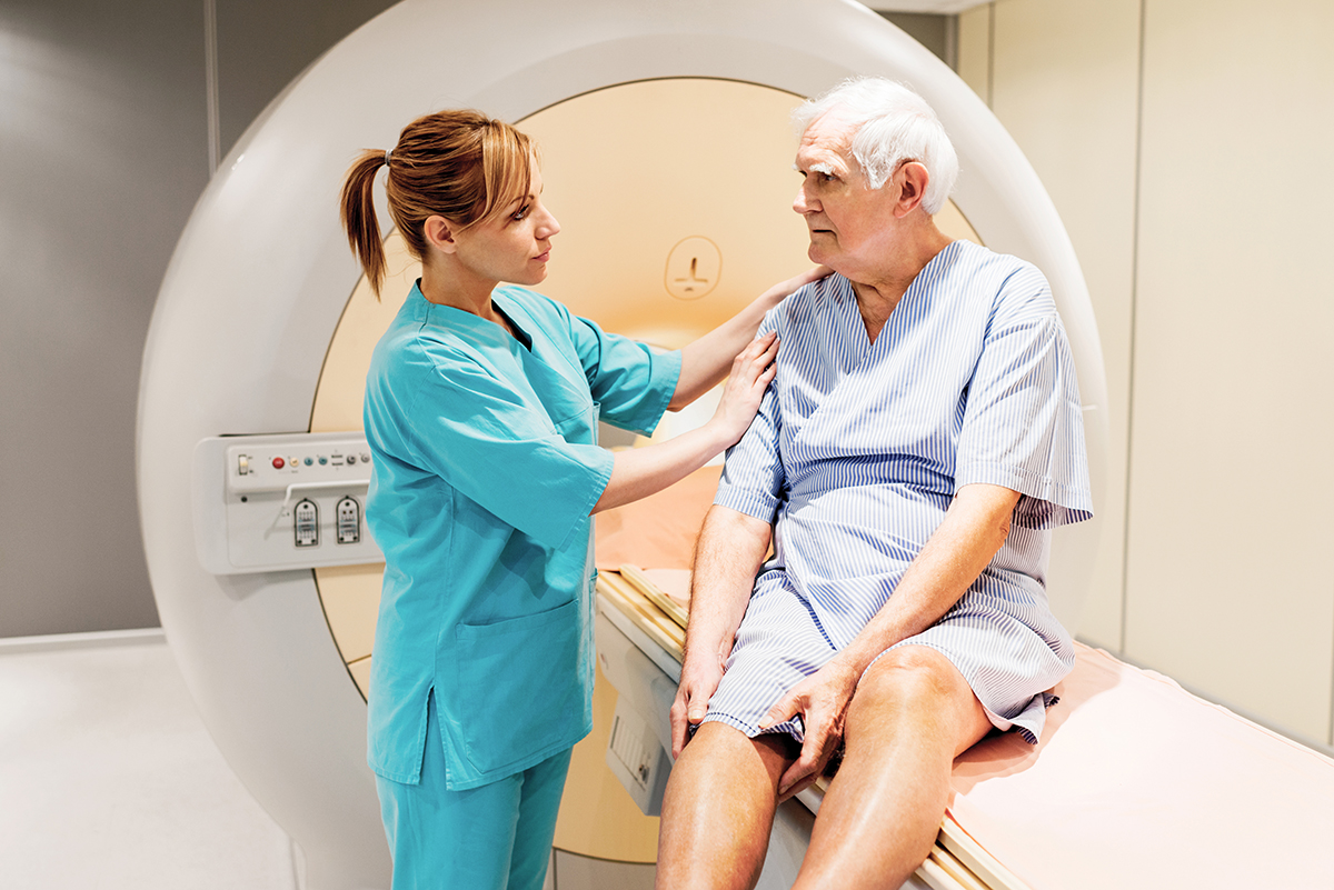 Female nurse preparing a mature patient for an MRI Scan.