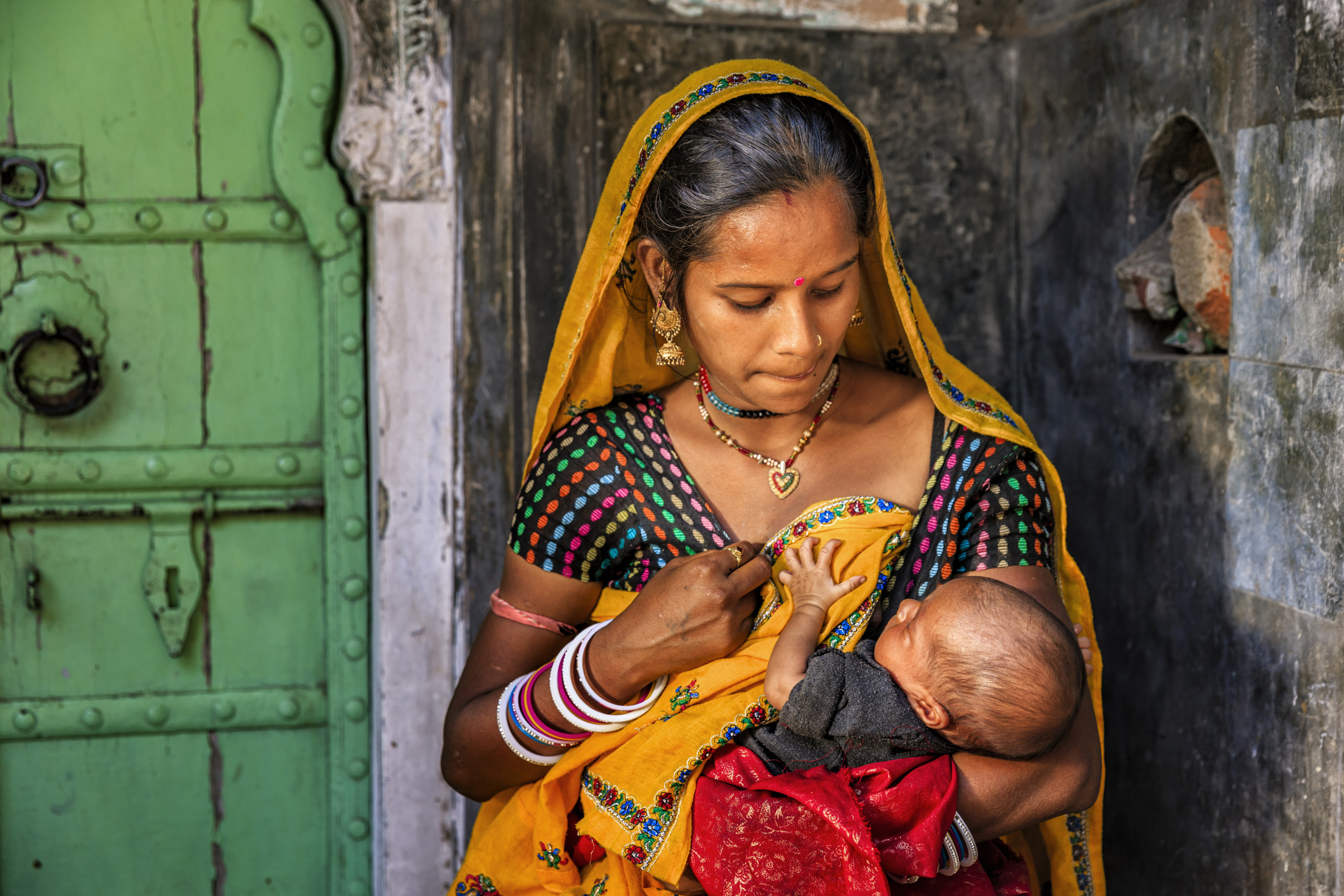 Indian woman feeding her newborn baby