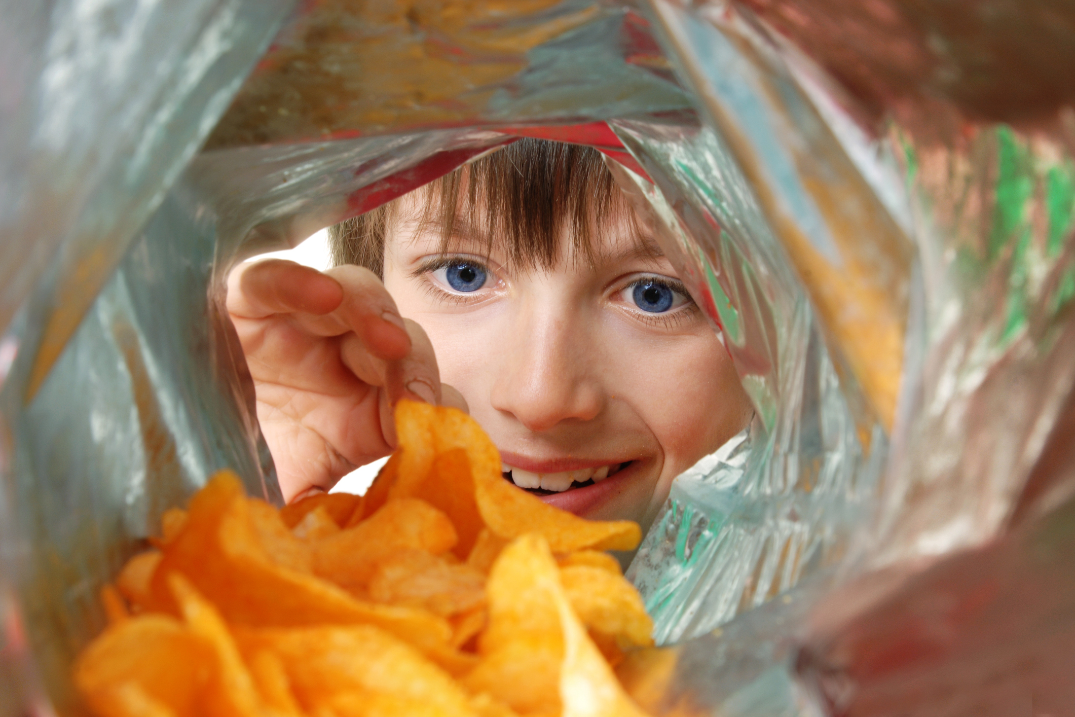 View from inside a potato chip bag of a boy enthusiastically looking in