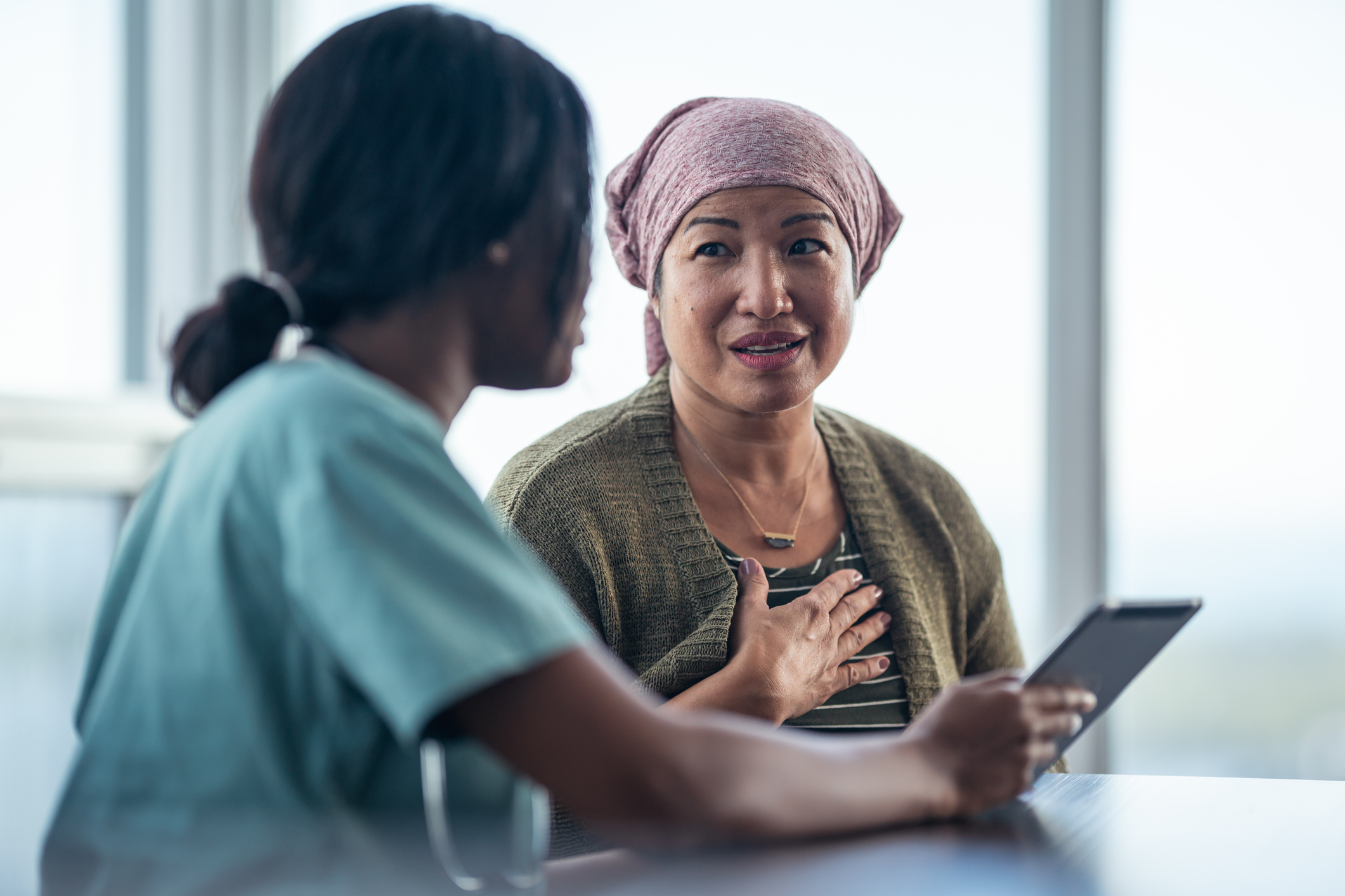 Woman looking at tablet with a female physician Woman looking at tablet with a female physician