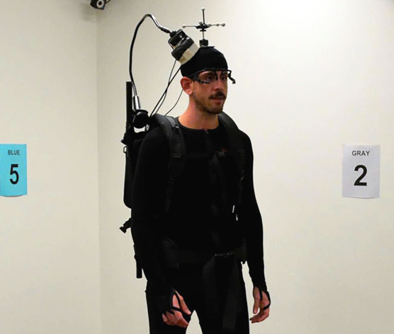 Man walking around room in backpack and headset