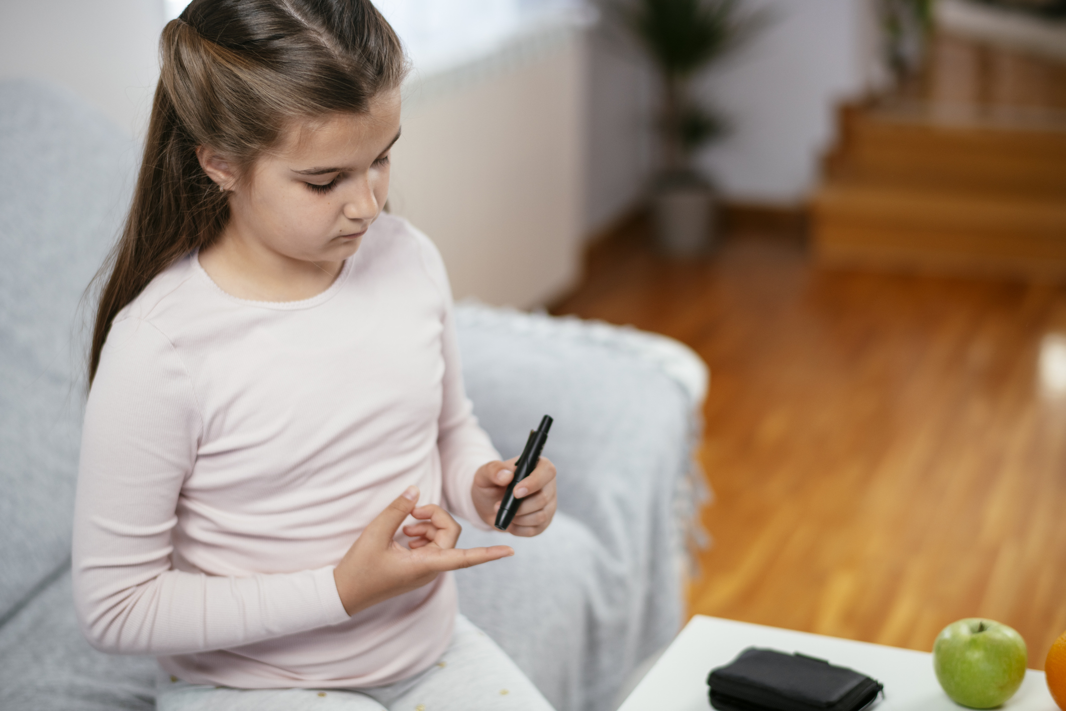 Teenage girl checking her blood sugar level Teenage girl checking her blood sugar level