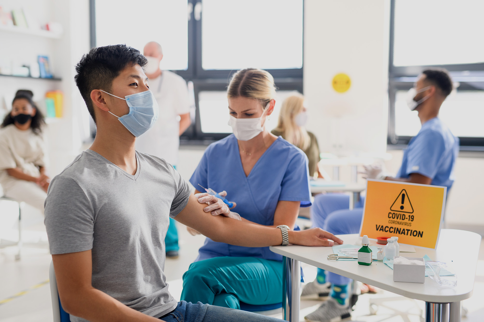 Man with face mask getting vaccinated in clinic