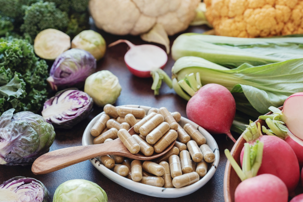 Fiber capsules in a bowl surrounded by fibrous vegetables