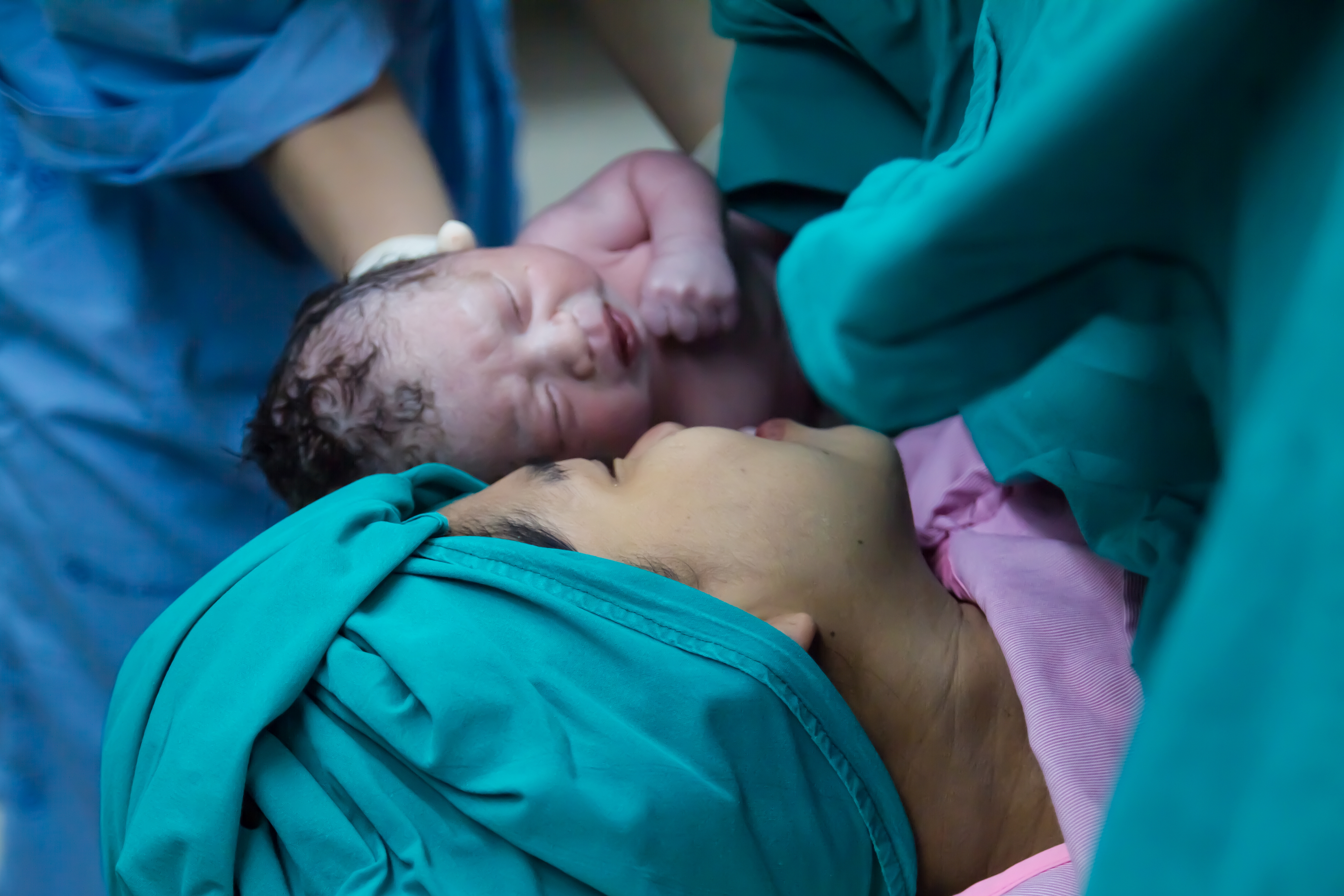 Mom and her newborn first meeting in operation room.