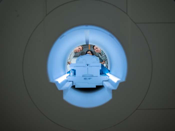 View through an fMRI scanner as three researchers peer inside. View through an fMRI scanner as three researchers peer inside.
