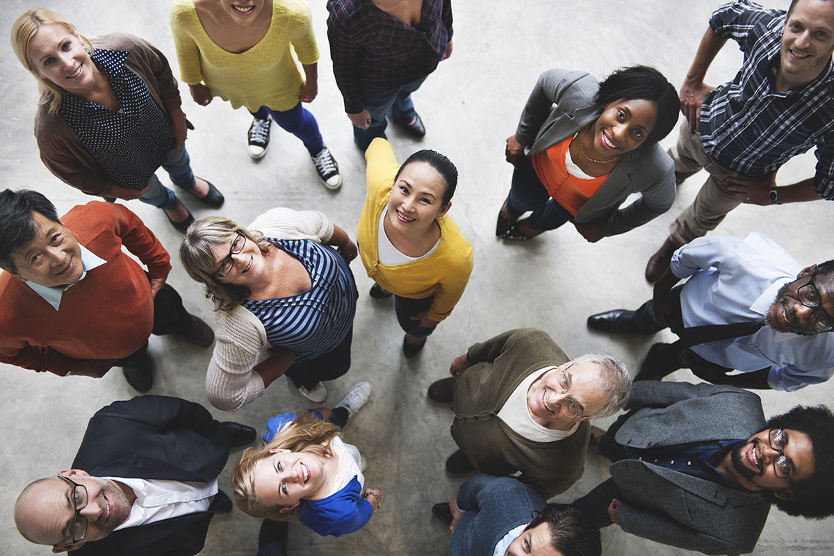 Bird’s-eye view of diverse people looking up and smiling.