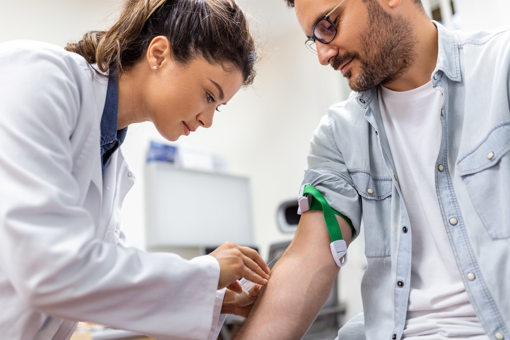 Phlebotomist collecting blood sample from a patient.