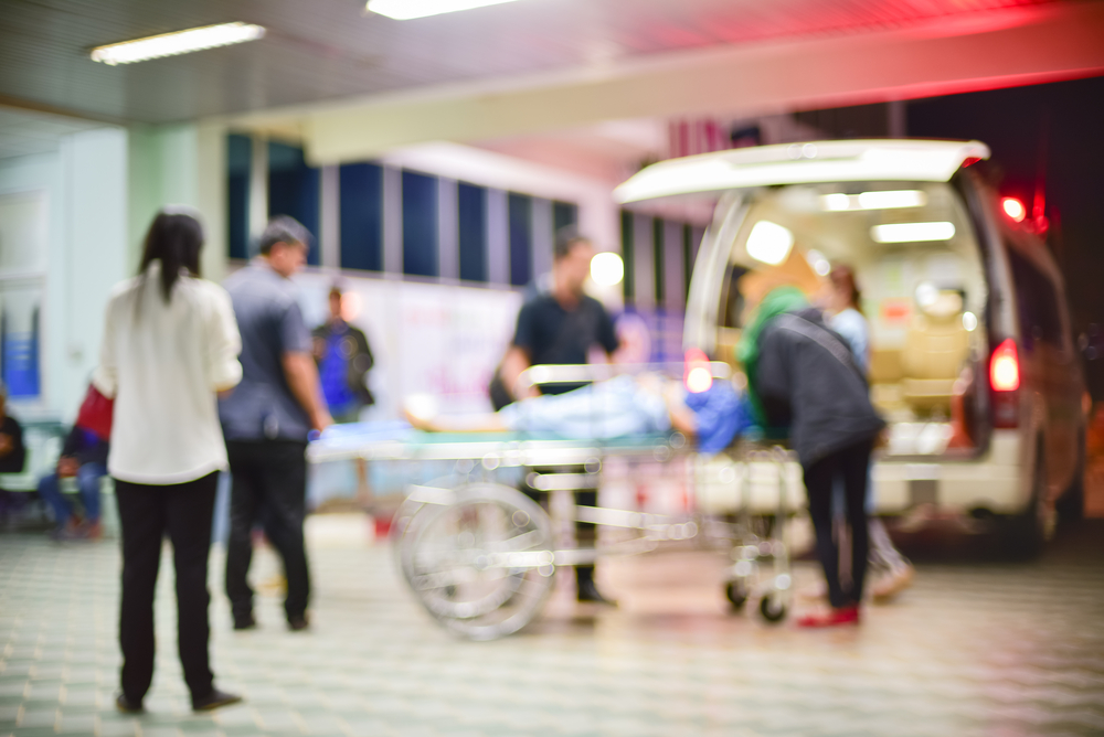 Blurred photograph of a patient being transferred from an ambulance.