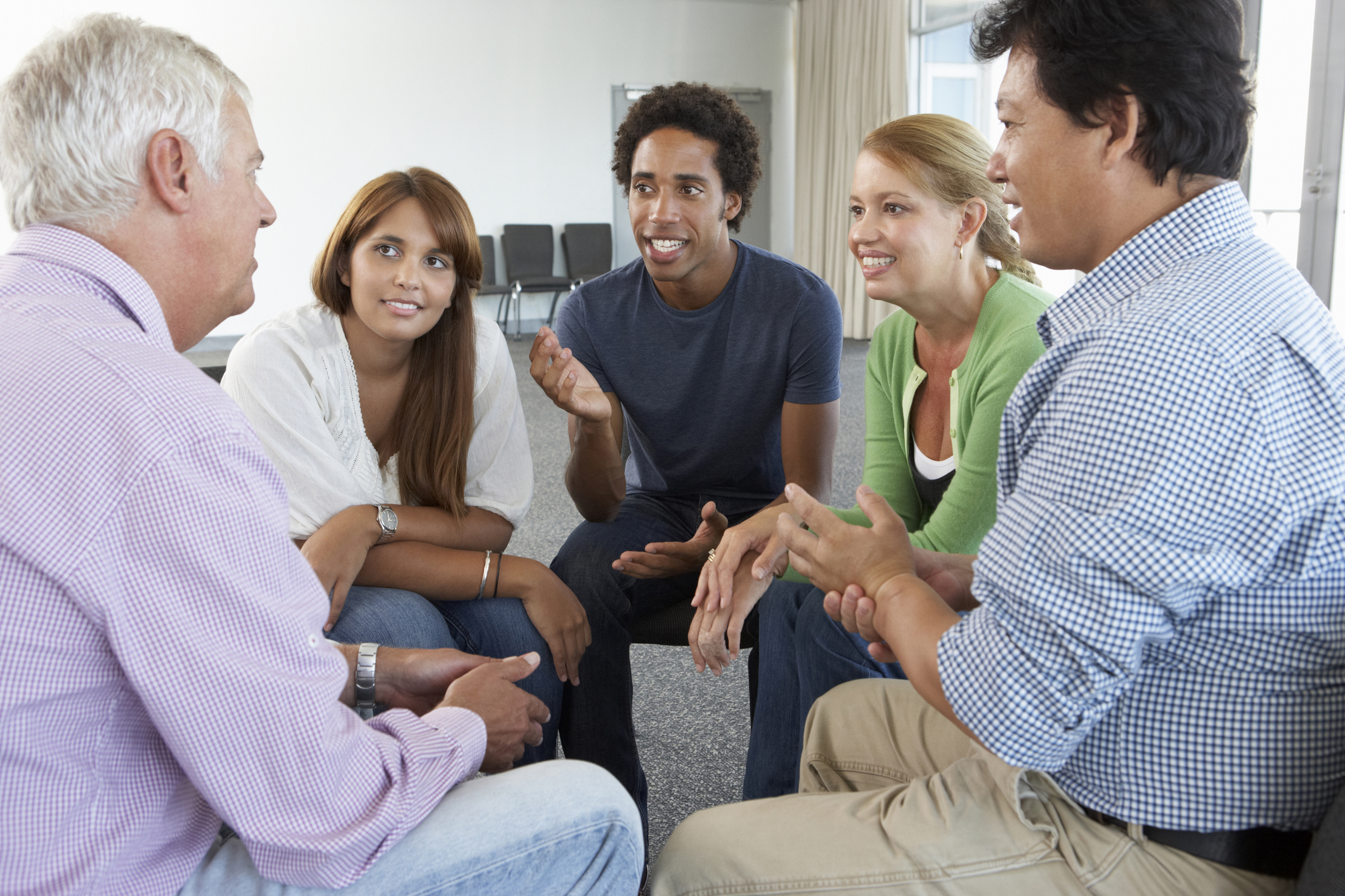 A diverse group of people talking in a circle