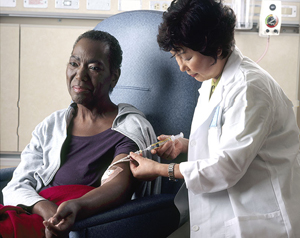 A nurse administering chemotherapy a woman through a catheter A nurse administering chemotherapy a woman through a catheter.