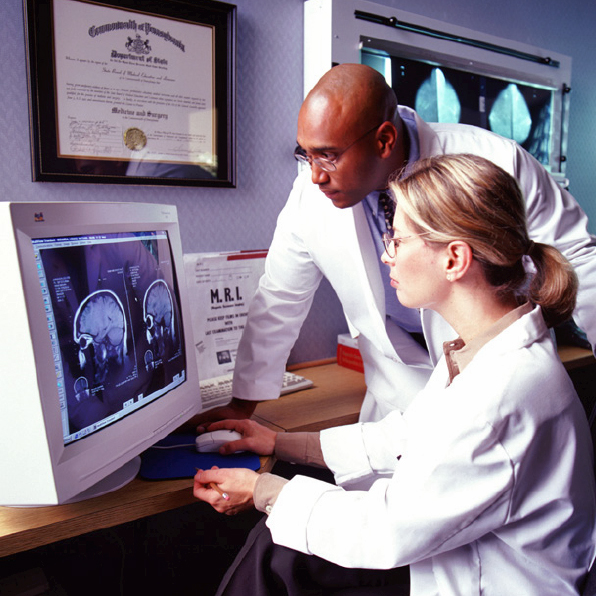 Two researchers looking at an MRI on a computer screen.