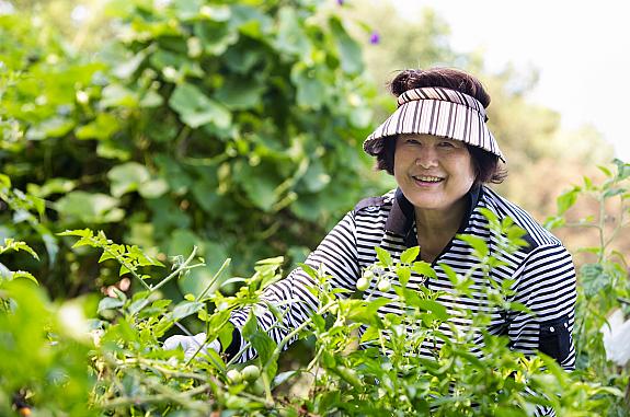 Woman in a garden smiling at the camera.