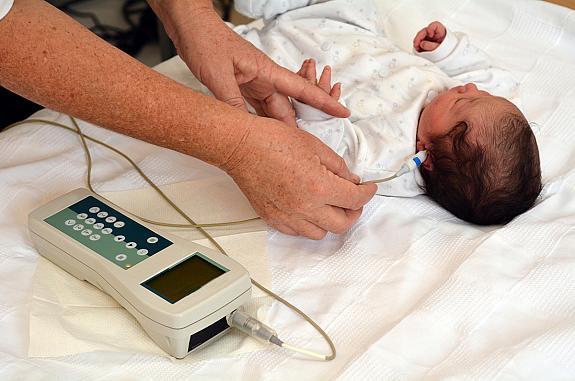 A newborn undergoes a hearing screening.