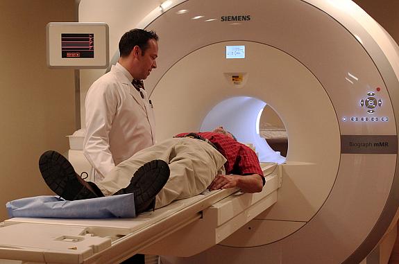 Imaging technologist talks to a patient before a scan in the fully integrated whole-body simultaneous PET/MRI device.