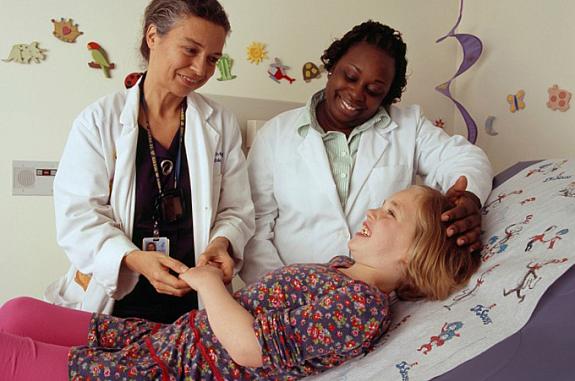 Nurse and doctor interacting with and laughing with patient