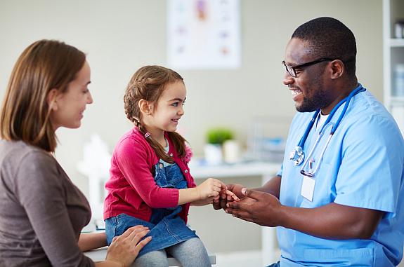 Small child and doctor talking in clinic