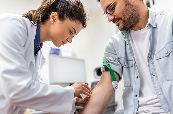 Phlebotomist collecting blood sample from a patient.
