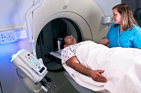 Technician preparing man for a CT scan.