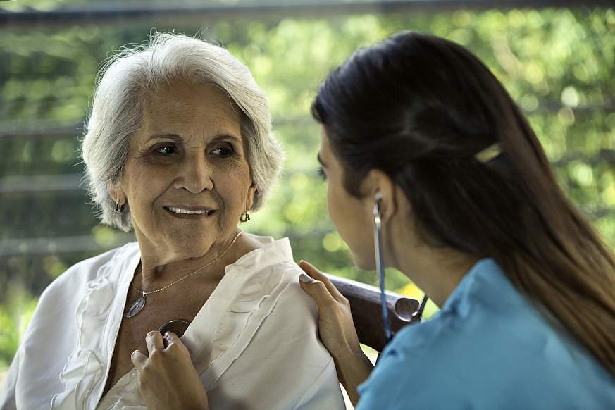 Heath themes. Female physician listens to senior patient's heart