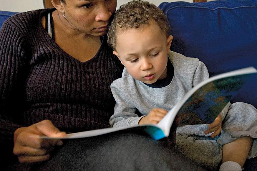 A mother reading to her young son.