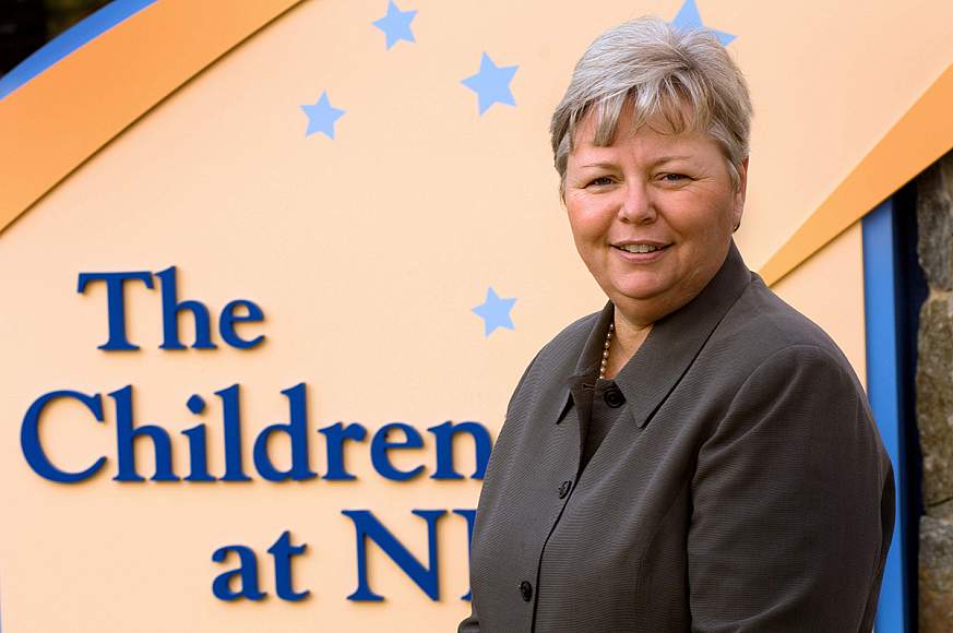 Portrait of Kathy Russell standing in front of the Children's Inn