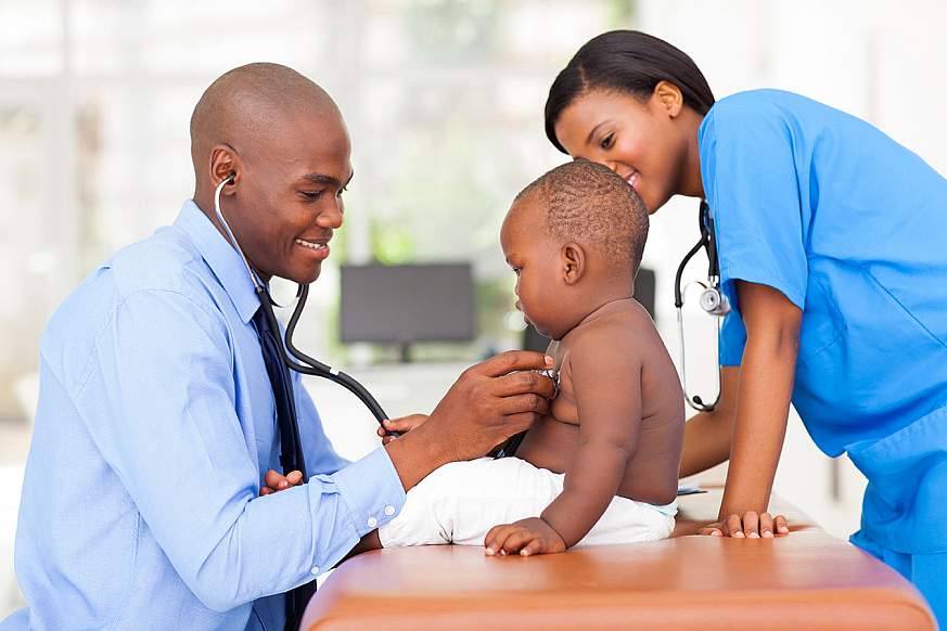 Image of two healthcare workers examining a child