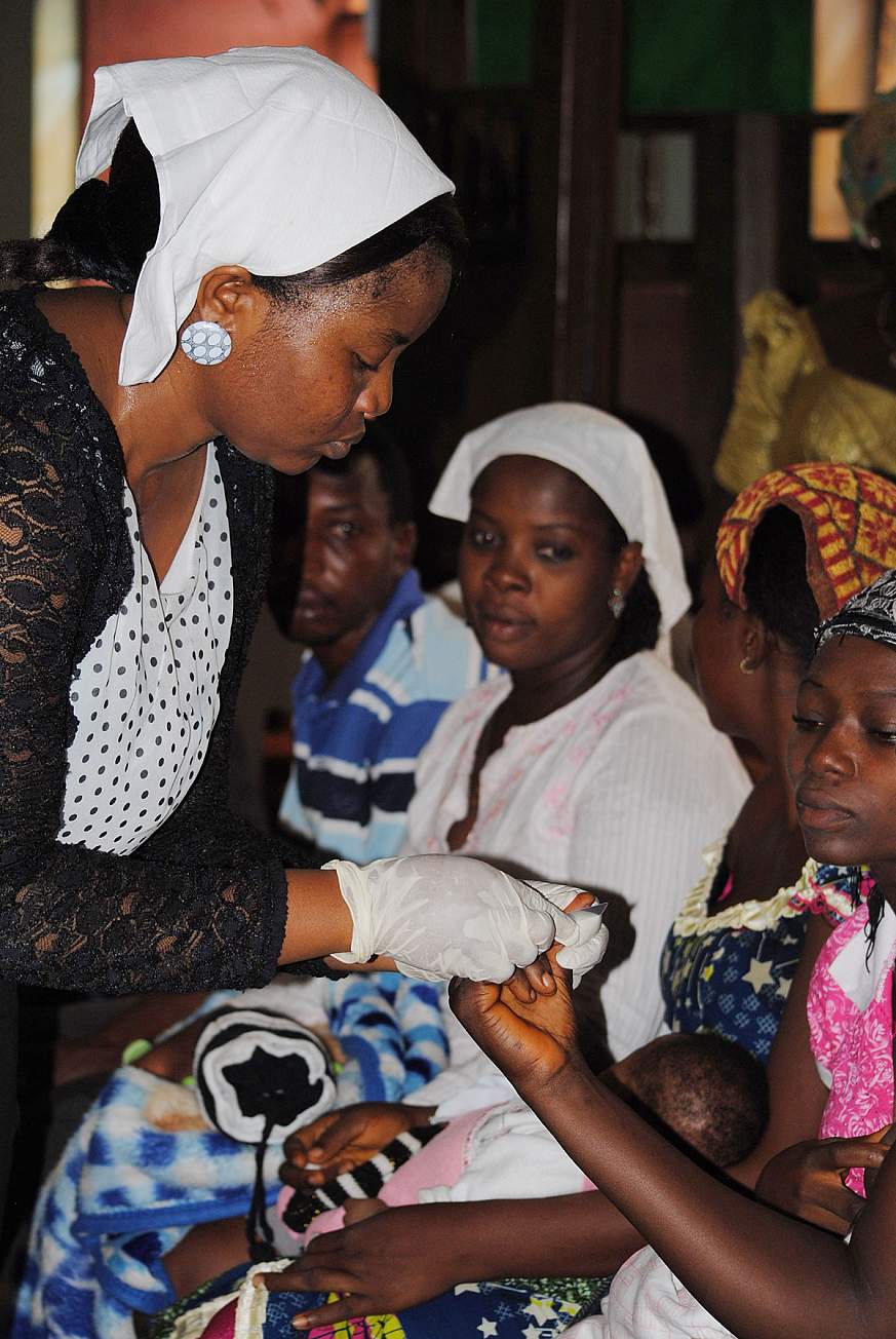 Image of a health worker testing women for HIV.