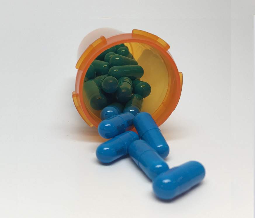 Capsules spill out of a prescription bottle