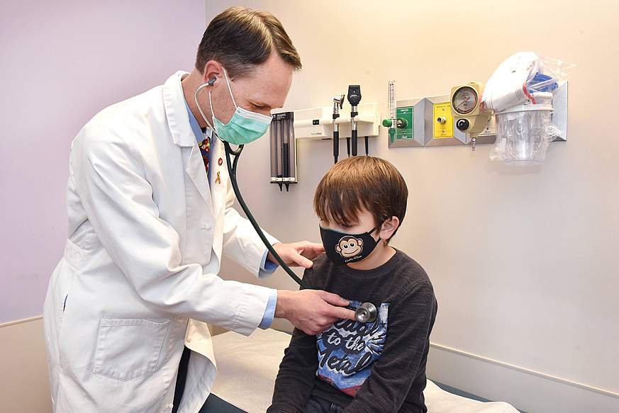 Image of a physician using a stethoscope to examine a child.