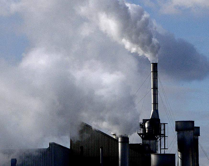 white cloudy emissions emerge from a factory complex