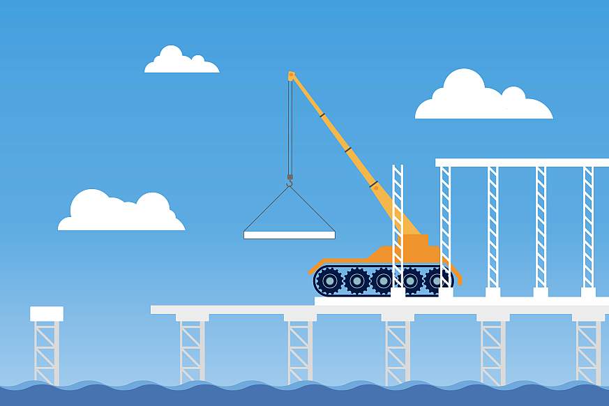 Crane truck building a bridge over a sea of water
