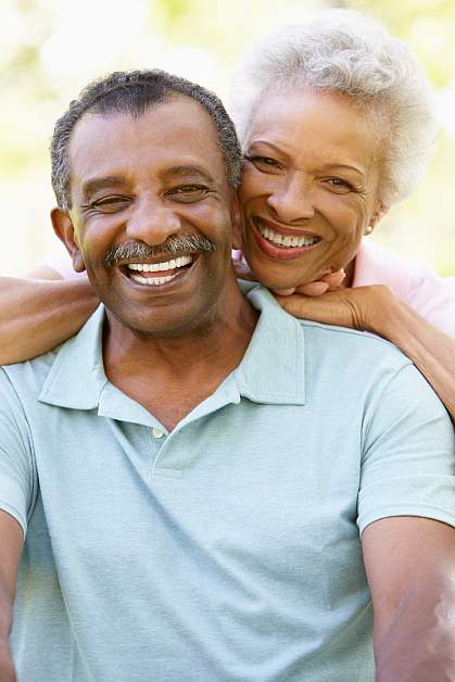 A retired couple smiling for the camera.