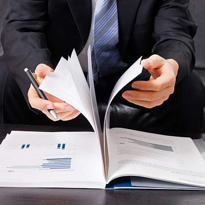 A business man flipping through a report.