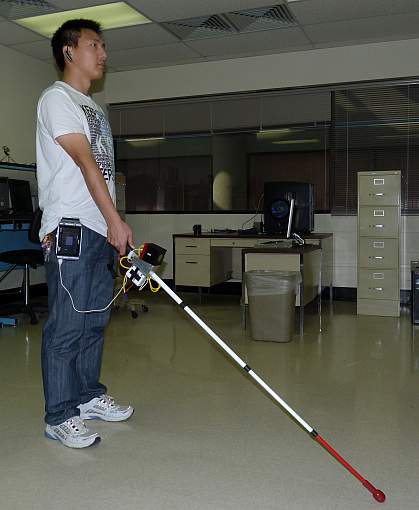 Image of a person holding a prototype co-robotic cane for the visually impaired