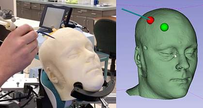 the image shows a hand holding a long thin device against a white mannequin head as well as a computer rendering of the head with the digital trackers.