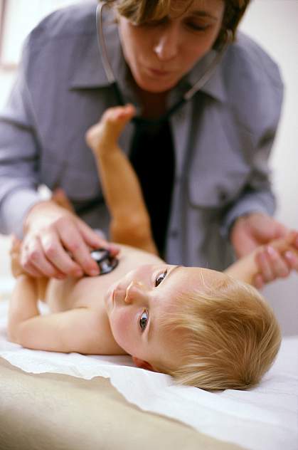 photo of an infant being examined by a doctor