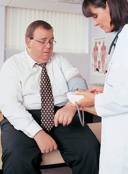 a photo of an obese man having his blood pressure taken by a doctor