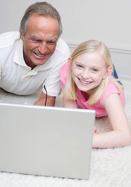 Picture of a grandfather assisting his son and grandson at the computer
