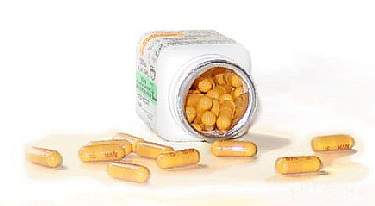 Photo of Gleevec tablets next to pharmaceutical bottle