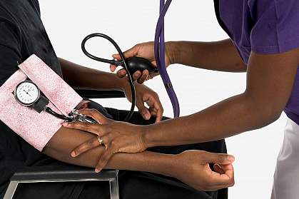 Photo of nurse taking an African American man's blood pressure.