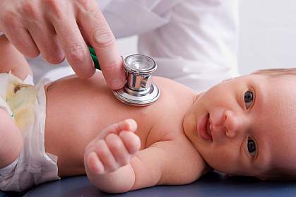 photo of an infant being examined by a doctor
