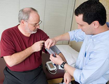 Photo of a doctor taking the blood pressure of an older man