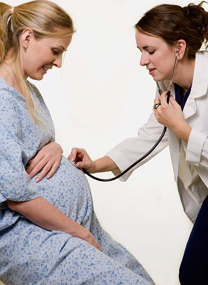 Photo of a pregnant woman being examined by a female doctor