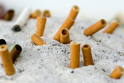 Photo of cigarettes snuffed out in a communal ashtray