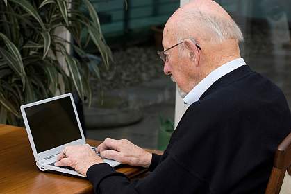 Photo of an older man using a laptop computer