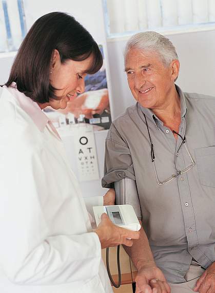 Photo of a female doctor checking the blood pressure of an older man