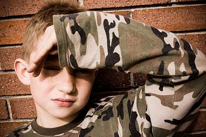  photo of a young boy shielding his eyes from a bright light